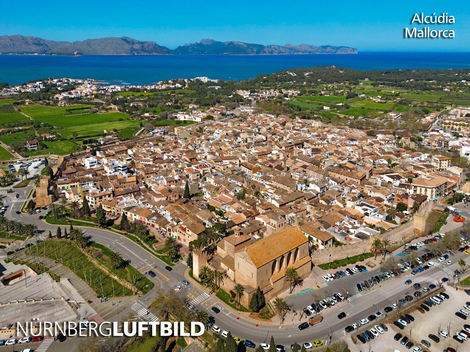 Luftbild von Alcúdia im Norden Mallorcas mit der ummauerten Altstadt auf der Landzunge zwischen den Buchten von Alcúdia und Pollença